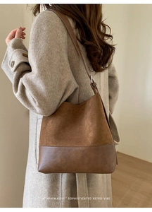 Minimalist large brown tote bag on model's shoulder with suede and leather textures