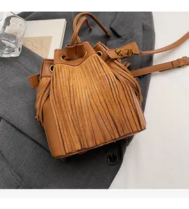 Détail du sac seau marron avec de longues franges et des finitions dorées chic