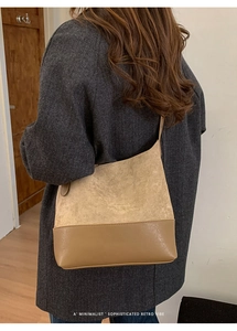 Detailed view of retro brown suede and leather patchwork shoulder bag on a model