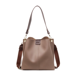 Sac seau en cuir marron avec deux bandoulières et logo de la marque sur fond blanc
