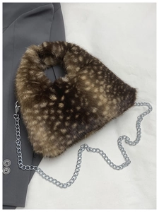 Detail of deer print plush bag with silver chain strap on a grey blazer outfit