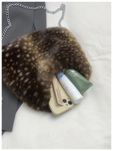 Detail showing high capacity plush deer print bag with silver chain and cosmetics