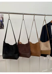 Macro view of four retro faux suede bucket bags in black, coffee, brown, and beige colors