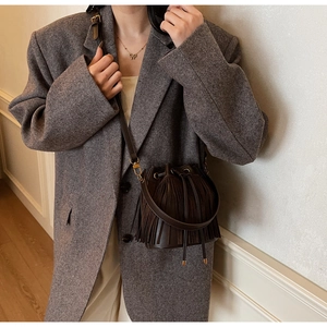 Détail du sac seau marron café avec de longues franges et une bandoulière réglable