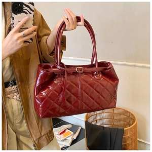 Chic burgundy quilted patent leather tote bag held by a model in a casual lifestyle setting