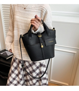 Detail of black lychee grain bucket bag with gold padlock and adjustable strap