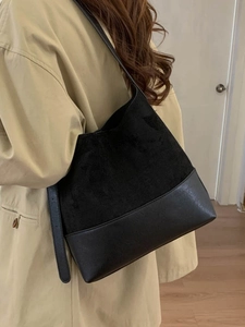 Elegante borsa tote nera in ecopelle mista indossata da una modella in interno
