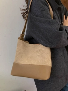 Borsa tote bicolore in pelle e camoscio con tracolla regolabile su cappotto