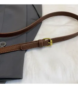 Detailed macro view of adjustable dark brown litchi grain leather strap with gold buckle