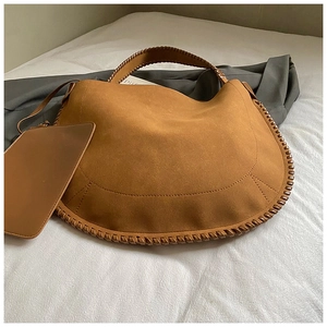 Vue détaillée du grand sac cabas en daim caramel avec bord tissé et pochette