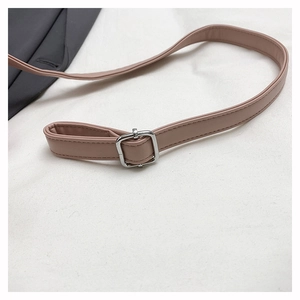 Detail of adjustable faux leather shoulder strap with silver buckle on plush bag