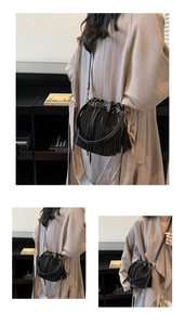 Détails du sac seau noir à franges avec cordon à anneau métallique et pompons en cuir