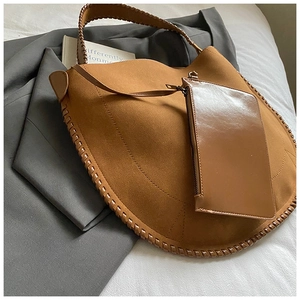 Détail du sac cabas en daim fauve avec bord tissé et petit sac à fermeture éclair assorti