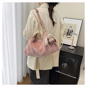 Close-up of pink plush handbag with soft faux fur texture and cute rabbit charm detail