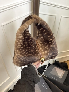 Faux fur animal print tote bag with gold pendant detail and chain strap shown held by hand