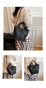 Detail of black pebbled leather bucket bag with gold lock and fashion lettering