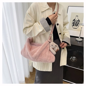 Detail of pink faux fur shoulder bag with leather strap and cute rabbit plush charm