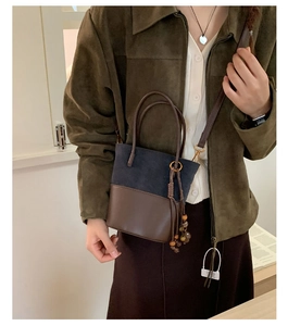 Detail of vintage bucket bag with navy suede and brown leather contrast stitching