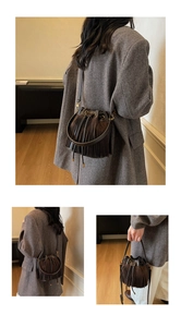 Détail d'un sac seau marron à franges montrant la fermeture et la texture