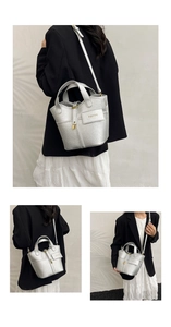 Detailed macro view of silver bucket bag with pebble texture and gold padlock charm