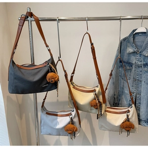 Detail view of large canvas tote bags in various colors hanging on a display rack