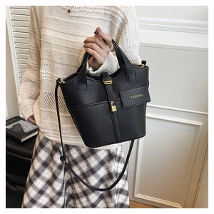Detail of black lychee leather bucket bag with gold padlock and fashion text