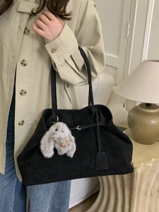 Minimalist black suede tote bag with plush bunny charm for casual commuting outfits