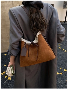 Borsa hobo in camoscio caramello con bordo in shearling bianco indossata da modella