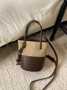 Retro khaki suede and brown leather bucket bag with dual handles and gold accents