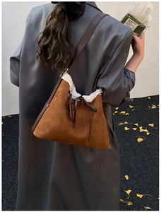 Dettaglio borsa a spalla vintage marrone con bordo in ecopelliccia bianca e fiocco