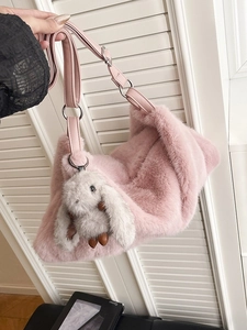 Pink faux fur hobo bag with adjustable strap and plush rabbit charm for women