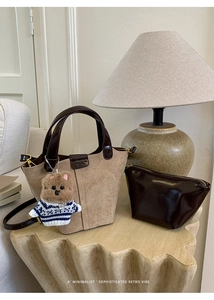 Detail of retro suede bucket bag set with leather handle and cute bear charm