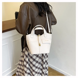 Chic beige lychee leather bucket bag with top handle and adjustable shoulder strap
