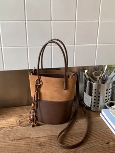 Retro bucket bag for women featuring khaki suede and dark brown leather with bohemian charms