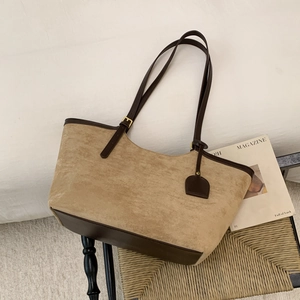 Vue détaillée du sac cabas en daim camel avec poignées en cuir marron et finitions