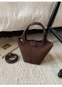 Detail der braunen Vintage-Wildlederbeuteltasche mit Ledergriffen und Logo-Prägung