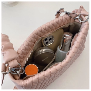 Pink quilted shoulder bag showing interior capacity with phone and cosmetics