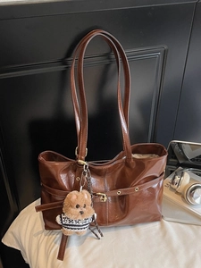 Deep brown glossy pleated tote bag with chic golden hardware and cute puppy charm