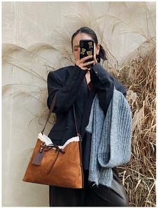 Borsa a secchiello in camoscio marrone con bordo in ecopelliccia bianca stile autunnale