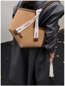 Detail of vintage woven tote bag with leather trim worn on shoulder over the side