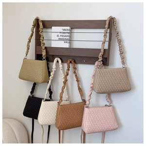 Detail view of colorful quilted underarm bags with ruffled shoulder straps in six colors