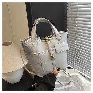 Macro detail of silver bucket bag with pebble leather texture and gold hardware accents