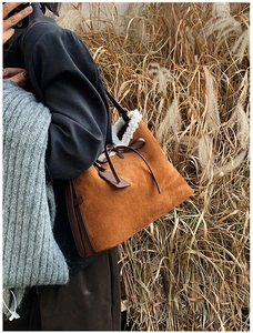 Dettaglio borsa tote in pelle scamosciata marrone con finiture in agnellino bianco