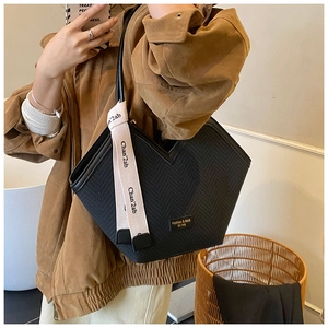 Detailed woven texture of black tote bag featuring unique V-shaped opening and stylish strap