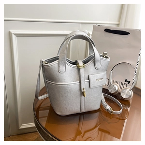 Close-up of silver litchi grain bucket bag with gold lock and mini fashion pouch