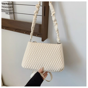 Detail of off-white quilted PU leather handbag with ruched handle and shoulder strap