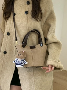 Klassische hellbraune Wildleder-Eimertasche mit Bärenanhänger für herbstlichen Stil