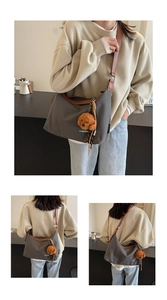 Detail of dark grey canvas hobo bag with brown faux leather trim and dog charm