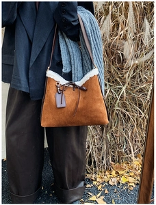 Dettaglio borsa tote in pelle scamosciata marrone con bordo in pelliccia sintetica bianca