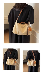 Detail of canvas tote bag featuring brown leather straps and a cute plush bear pendant